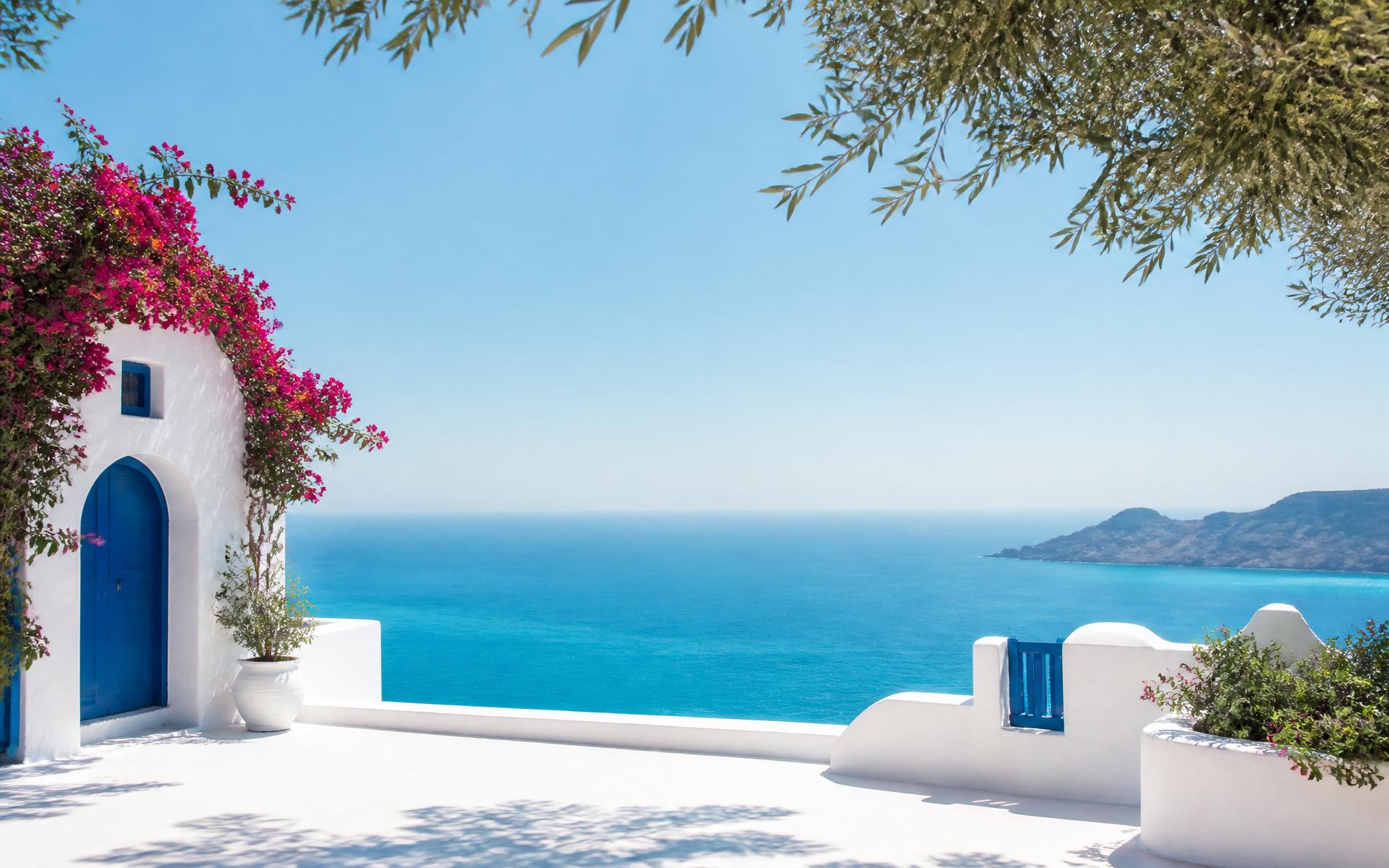 Terrasse blanche dominant la mer Égée turquoise